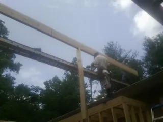 Carpenter setting a ridge beam over a new addition frame — Ice Dam Removal by Roofing Brothers in Willow